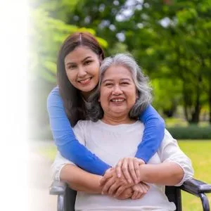 A woman supporting an older loved one outdoors