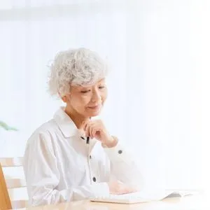 An older woman sitting comfortably in a chair at home